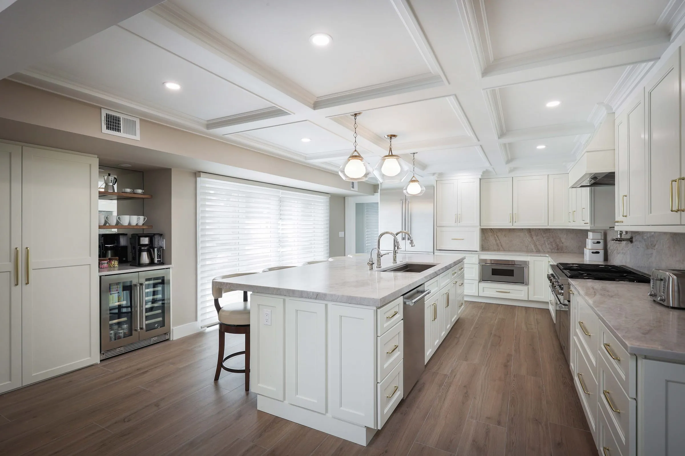 White inset cabinetry under a coffered ceiling